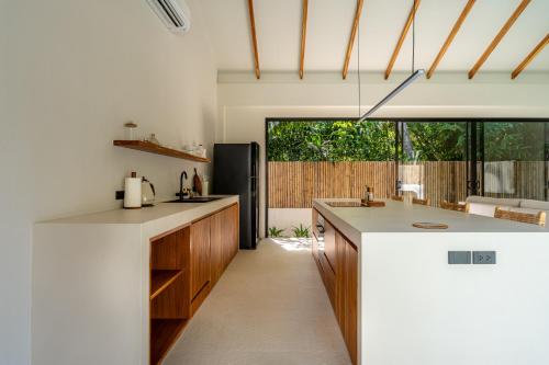 a kitchen with white countertops and a large window at K Villas Phangan 04 in Ban Madua Wan