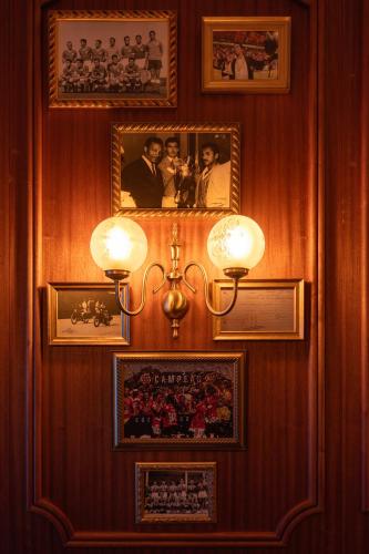 a wall with pictures and a light on it at 1904 Benfica Hotel FLH Hotels in Lisbon