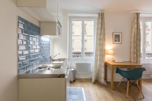 - une cuisine avec un évier et un bureau dans la chambre dans l'établissement Les Toits de Paris, à Paris