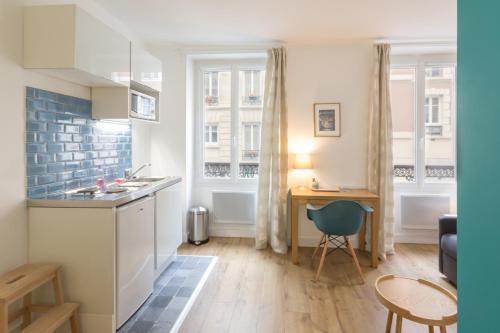 cocina con fregadero y escritorio en una habitación en Les Toits de Paris, en París