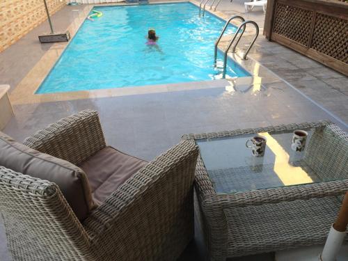 een zwembad met twee stoelen en twee personen bij Guest house Ashdod-beach in Ashdod