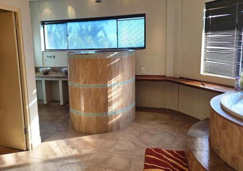 a bathroom with a wooden barrel in the middle of a room at The White House at Plattekloof in Plattekloof