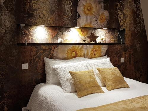 a bed with white pillows and flowers on a wall at la blanchetière in Francueil