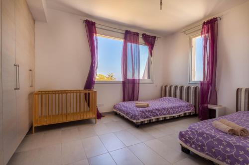 a bedroom with two beds and a window at Akefalou Bay Villa in Protaras