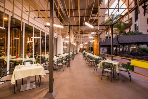 a restaurant with tables and chairs in a building at Hotel Beatriz Playa & Spa in Puerto del Carmen