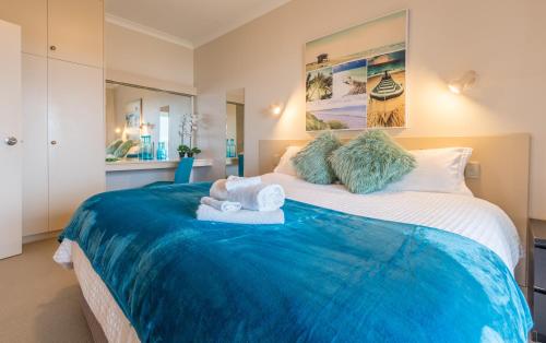 1 dormitorio con 1 cama grande y toallas. en The Bluff Resort Apartments en Encounter Bay
