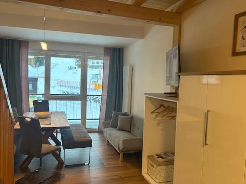 a living room with a table and a couch at Appartement HochOben in Planneralm