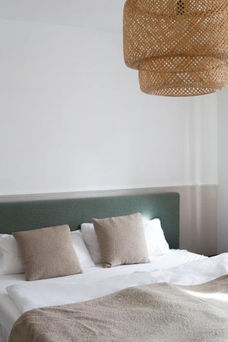 a bed with a green headboard and two pillows at FelsenSuite Panorama Essing in Essing