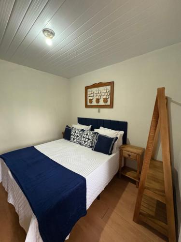 a bedroom with a bed with blue and white sheets at Pousada Dom Luiz in Ouro Preto