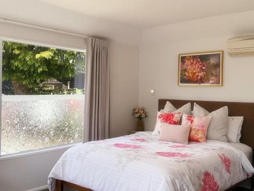 a bedroom with a bed and a large window at Cozy & Sunny Room-Near City, Short Drive to City Center & Coast in Christchurch