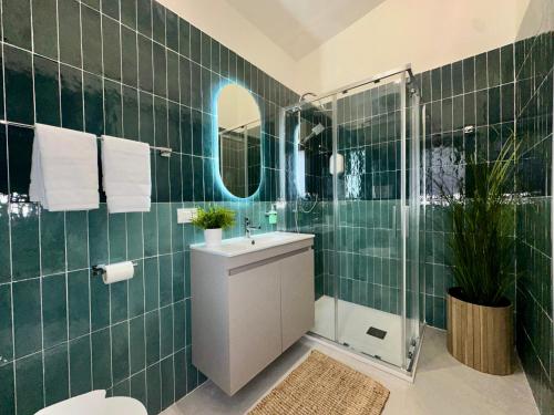 a green tiled bathroom with a sink and a shower at Casa Manzella Apartments in Cinisi