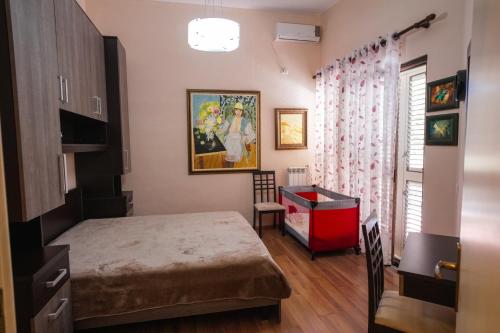 una camera da letto con un letto, una scrivania e una finestra di Vila MeriS a Durrës