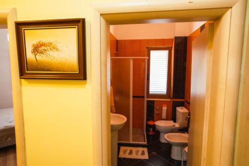 un bagno con due servizi igienici e un lavandino di Vila MeriS a Durrës