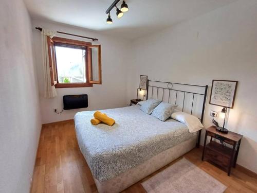 a bedroom with a bed with a yellow pillow on it at La Terraza de Escarrilla, con piscina in Escarrilla
