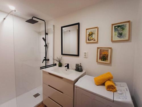 a bathroom with a sink and a mirror and a shower at La Terraza de Escarrilla, con piscina in Escarrilla