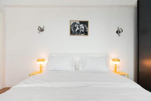 a bedroom with a white bed with two lamps at Luxury Elegant Pipera New Apartment in Voluntari