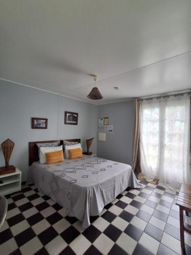 a bedroom with a bed and a checkered floor at Le four à pain in Saint-Philippe