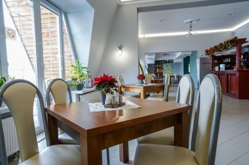 a dining room with a wooden table and chairs at Hotel Maraton in Kielce
