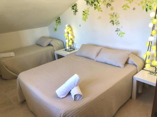 a bedroom with a bed with a rolled up towel on it at Rainbow Home Coll Verd in Playa de Gandia