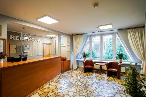 a waiting room with a waiting table and chairs in a hospital at Hotel Maraton in Kielce
