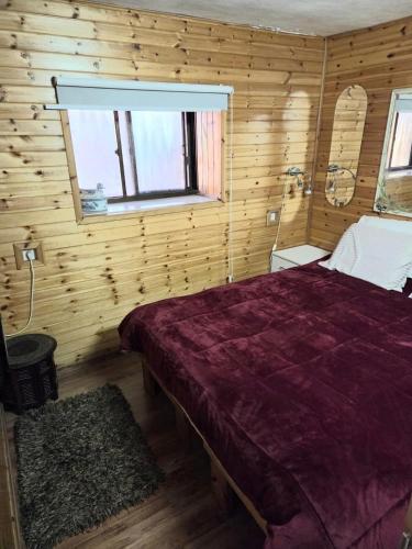 a bedroom with a bed in a wooden room at Among the cherry trees - B&B 1 Hermon in Metulla