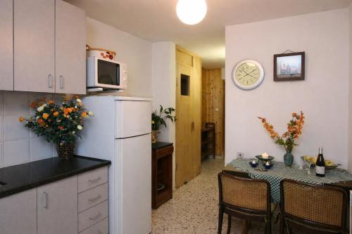 a kitchen with a refrigerator and a table with chairs at Among the cherry trees - B&B 1 Hermon in Metulla