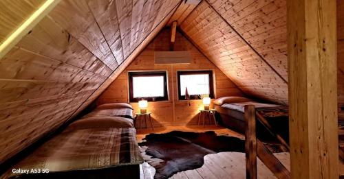 a room with two beds in a wooden attic at Dovolenkový dom Jazierko in Prievaly