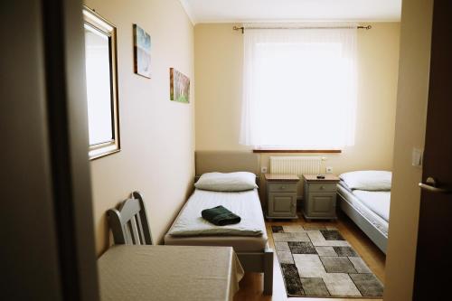 a small room with two beds and a window at Noclegi Kochlice in Kochlice