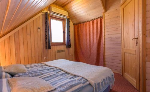 a bedroom with a bed in a wooden room at Apartments Brunarica in Moravske Toplice