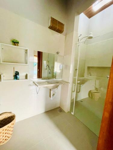 a bathroom with a glass shower and a sink at Recanto do cajueiro in Flecheiras