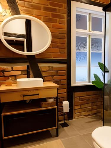a bathroom with a mirror and a sink at Casa Enxaimel em Pomerode SC 01 in Pomerode