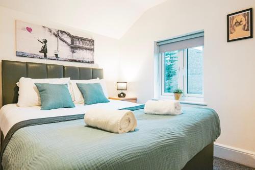 a bedroom with a large bed with two pillows on it at Gloucester 5 Bedroom Cosy Home-Work or Leisure in Gloucestershire