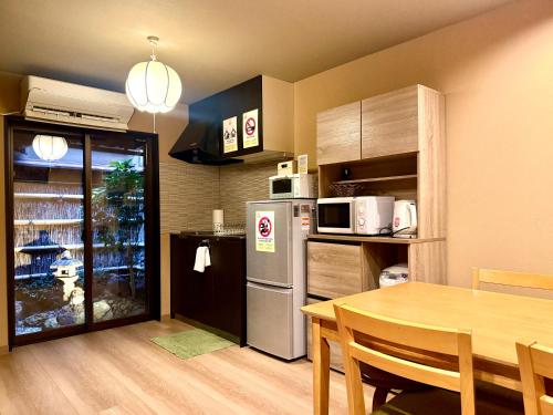 a kitchen with a table and a refrigerator and a dining room at 京宿日和 聚楽 Hiyori Juraku in Kyoto