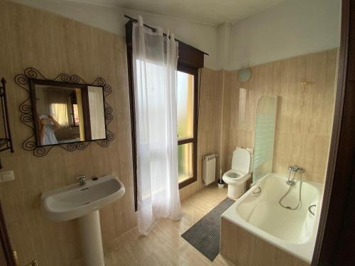 a bathroom with a sink and a toilet and a mirror at La Venta in Arguedes