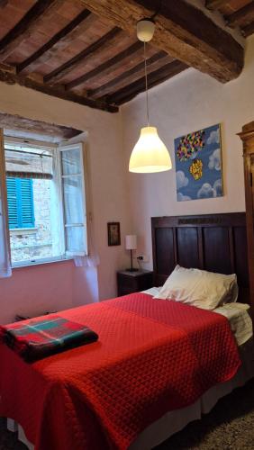 a bedroom with a red bed with a red blanket at La Casa Di Dina in Castelmuzio