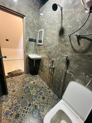 a bathroom with a shower and a toilet and a sink at Celebrations Party House in Kolhapur