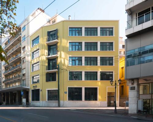 a yellow building on the side of a street at Limehome Athens Agora in Athens