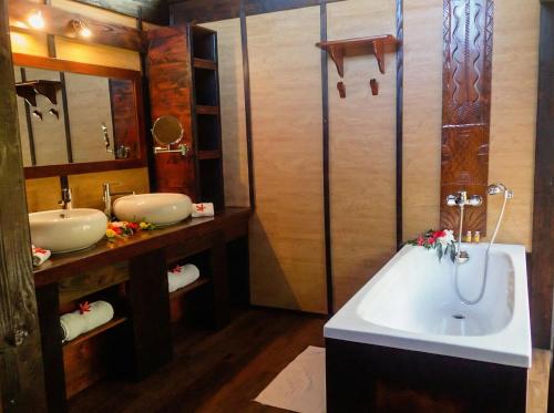 a bathroom with two sinks and a bath tub at Fare PEA ITI Romantic Lodge in Patio