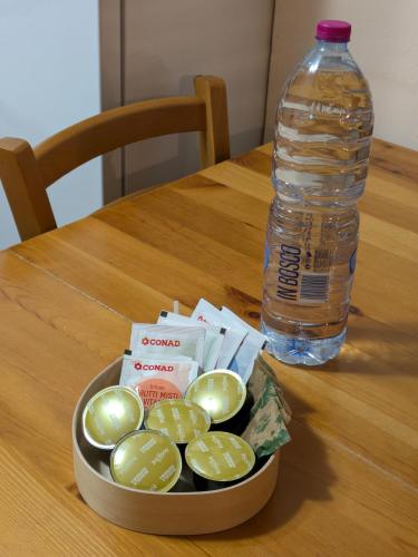 a bowl of green onions and a bottle of water at Appartamento Cedro - Centro Aprica - Park - WiFi in Aprica