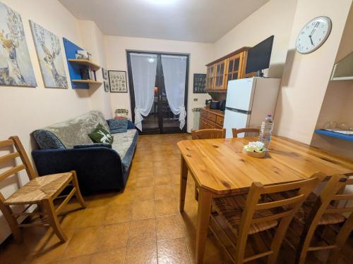 a kitchen and living room with a table and a couch at Appartamento Cedro - Centro Aprica - Park - WiFi in Aprica