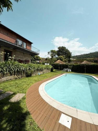 a swimming pool in a yard next to a house at Casa das Castanhas - Cinfães, Viseu in Cinfães