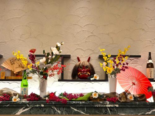 a table with flowers and a clown in a mirror at Richmond Hotel Akita Ekimae in Akita
