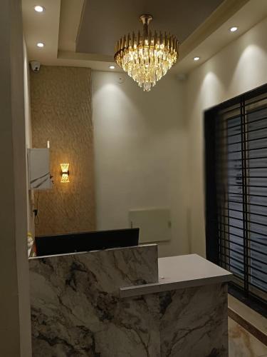 a lobby with a marble counter and a chandelier at Shree Guru Ashray in Ujjain