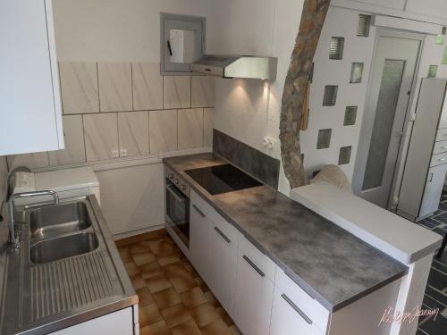 eine kleine Küche mit Spüle und Herd in der Unterkunft Cottage with River Views, Uzer in Uzer