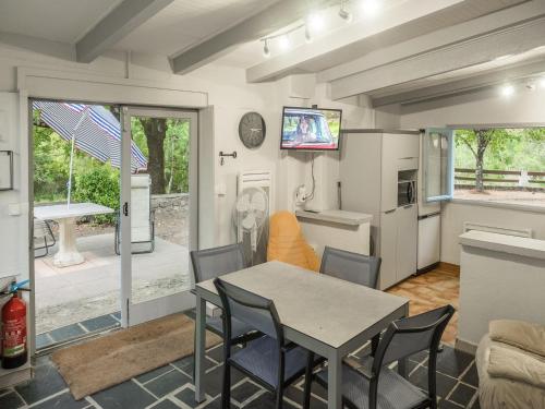 eine Küche und ein Esszimmer mit Tisch und Stühlen in der Unterkunft Cottage with River Views, Uzer in Uzer