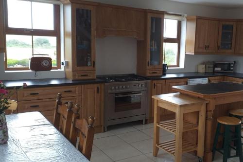 a kitchen with wooden cabinets and a stove top oven at Sleeps6-FamilyFriendly-FreeParking-Garden in Ballybunion
