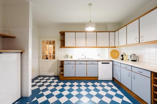 a kitchen with white cabinets and a checkered floor at Eighteen21 Houses - Casa de São Domingos in Lisbon