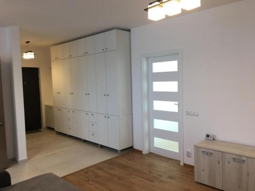 a large room with white cabinets and a door at Two rooms Vivo Metro Amethyst in Floreşti