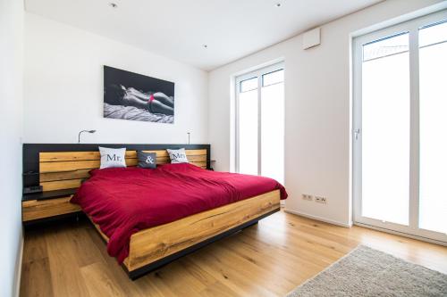 a bedroom with a large bed with a red blanket at Residenz Mont Royal in Traben-Trarbach