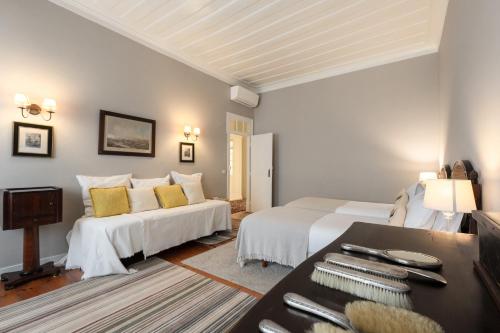 a bedroom with two white beds and a table at Eighteen21 Houses - Casa de São Domingos in Lisbon